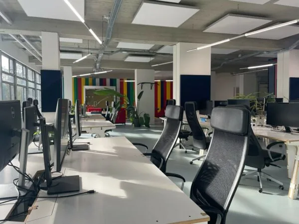 Moderne en ruime kantoortuin aan de Van Leijenberghlaan met werkplekken, ergonomische stoelen en kleurrijke wandpanelen.